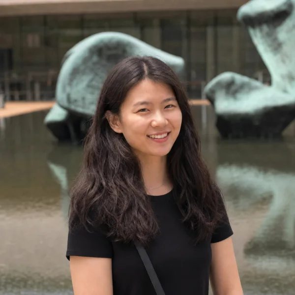 Sungrok Choi smiling in front of an outdoor sculpture.